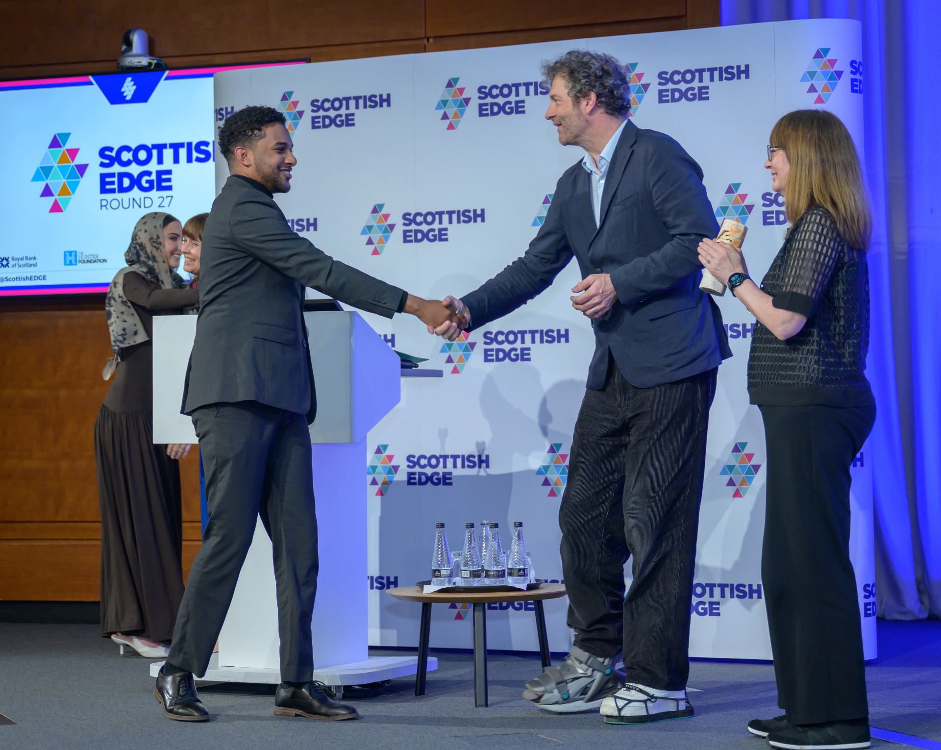 Ahmed Sharaf shaking hands on stage at Scottish EDGE Round 27 after receiving the Future EDGE award